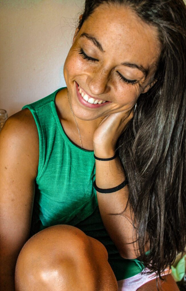 ragazza che sorride, maglia verde, capelli castani