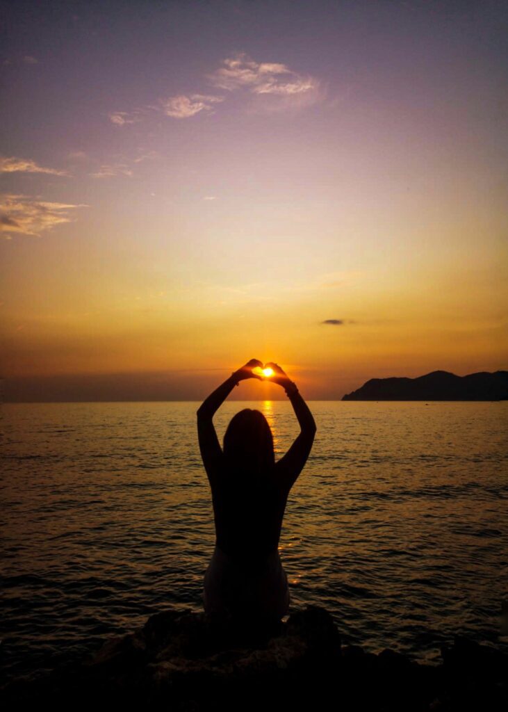 Silhoutte ragazza al tramonto con mani a cuore