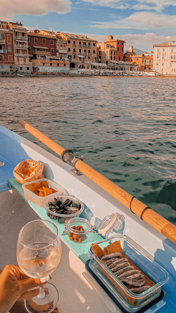 aperitivo in scialuppa, olive, focaccia, muscoli, bicchiere di vino, mare, barca