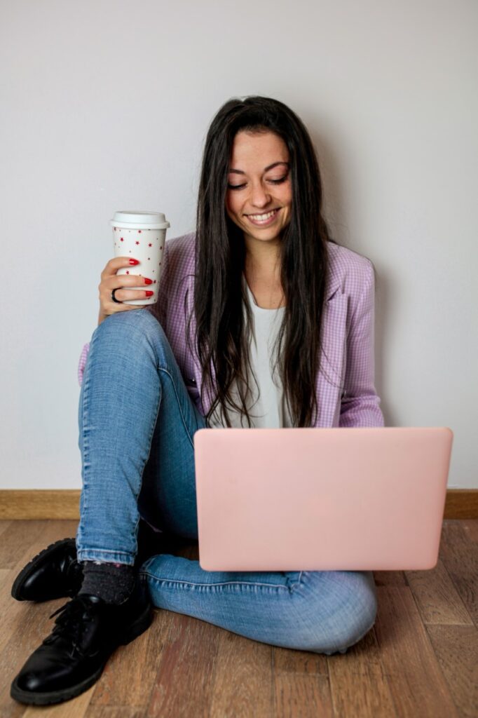 Chi sono. Ragazza seduta per terra con computer e tazza