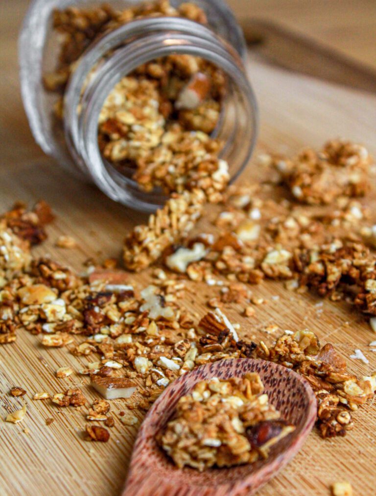 granola con frutta secca: barattolo di vetro, cucchiaio di legno, tagliere