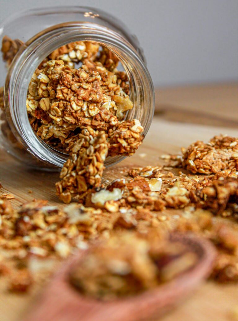 granola con frutta secca: barattolo di vetro, cucchiaio di legno, tagliere