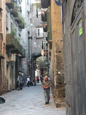 Strade di Napoli, uomo che cammina, case di pietra