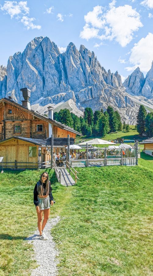 Gruppo delle Odle: ragazza che sorride, rifugio di legno di montagna, montagne, verde, prato, cielo azzurro