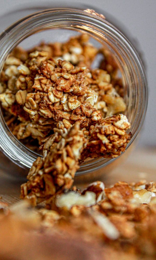granola con frutta secca: barattolo di vetro, cucchiaio di legno, tagliere