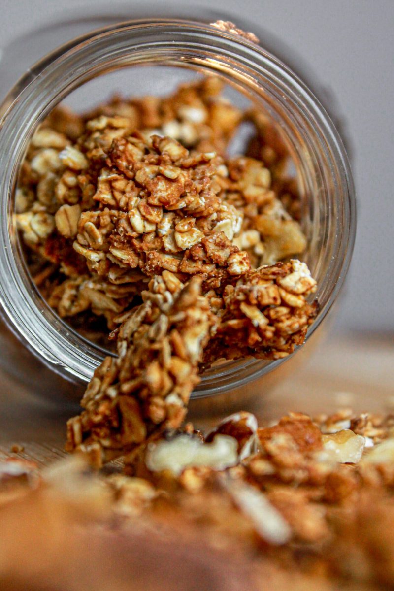 granola con frutta secca: barattolo di vetro, cucchiaio di legno, tagliere