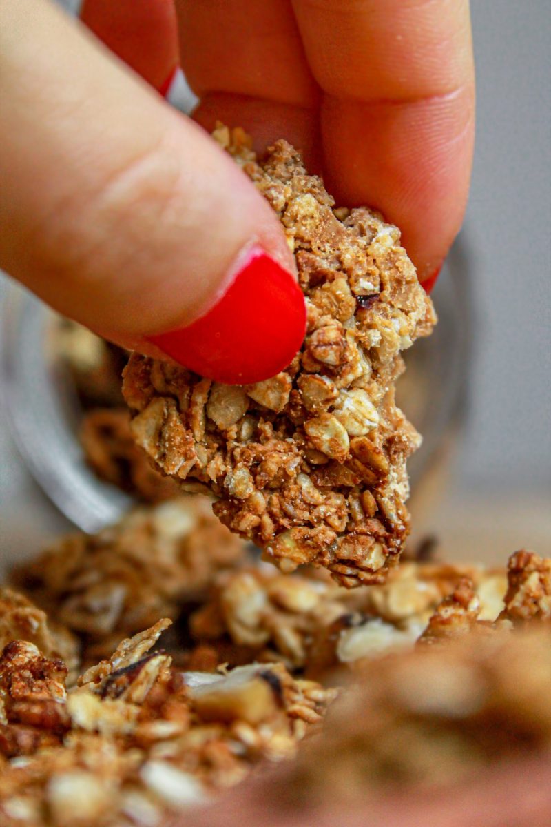 granola con frutta secca: barattolo di vetro, dita, tagliere